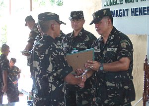 MGen. Arthur Tabaquero giving certificates to graduate soldiers